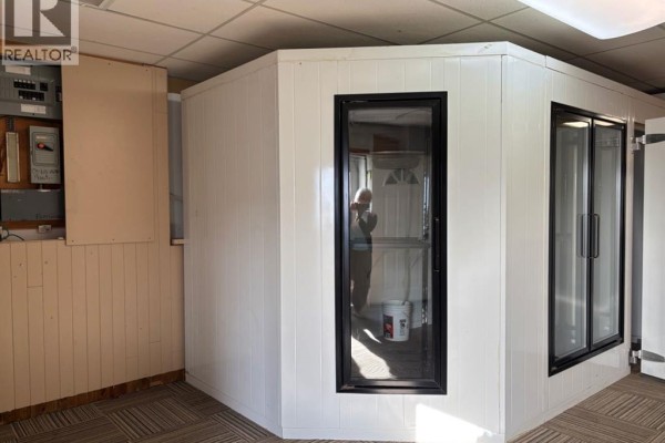Interior view of a walk-in cooler with glass doors and a small utility closet. - 121 Center Street W, Vulcan