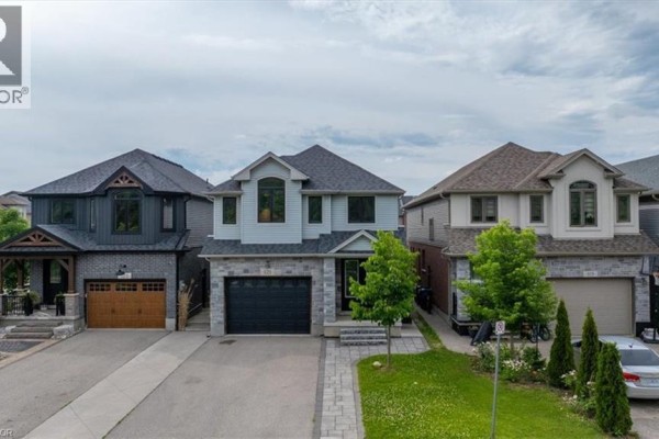 Front facade of a modern two-story house with a gray stone base and light blue siding. - 121 Dallan Drive, Guelph