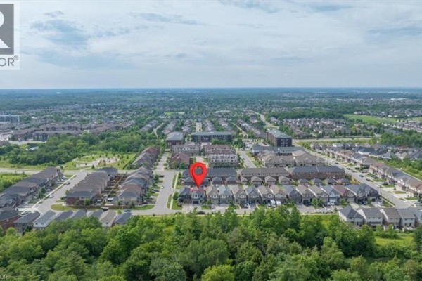 Panoramic aerial view of a new housing development surrounded by dense green forest. - 121 Dallan Drive, Guelph