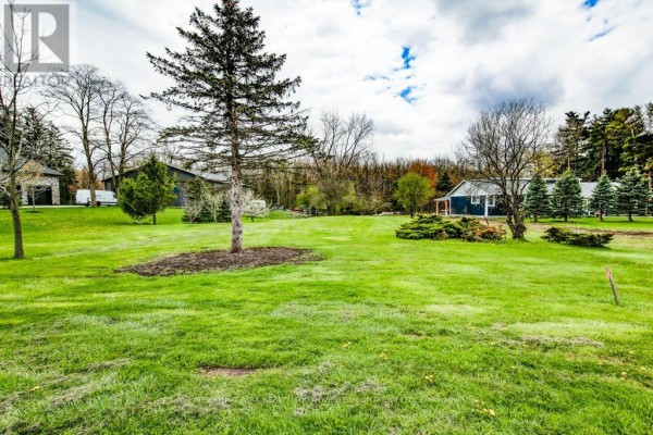 Wide view of a large, green lawn with scattered trees and two houses. - 121 Dodge Drive, Kitchener