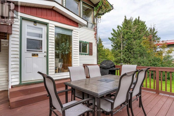 Outdoor dining table with chairs and a barbecue on the wooden deck. - 121 Hamlet Road, Blue Mountains