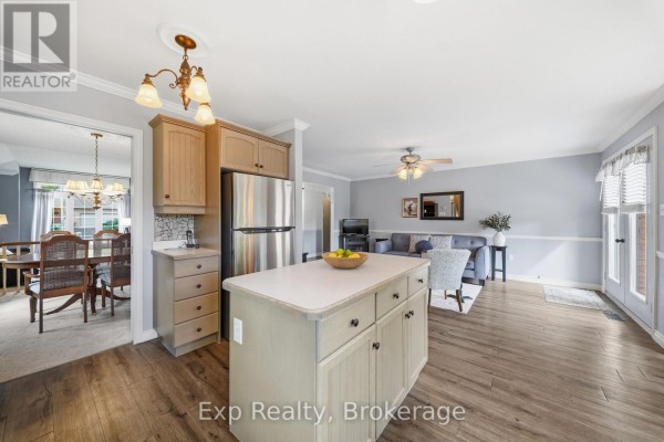 Kitchen island, stainless steel refrigerator and open concept living area - 121 Simcoe Street Greater Napanee