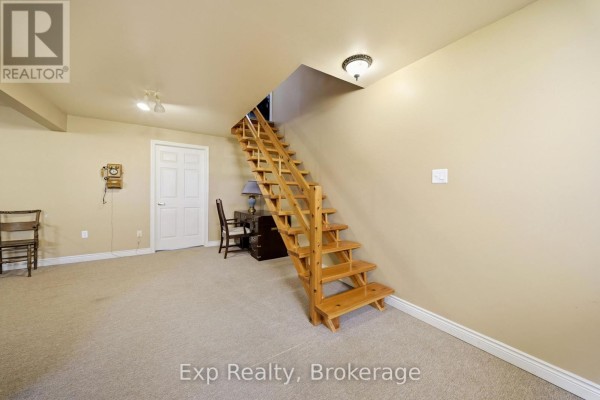 Wooden staircase and desk in a carpeted room - 121 Simcoe Street Greater Napanee