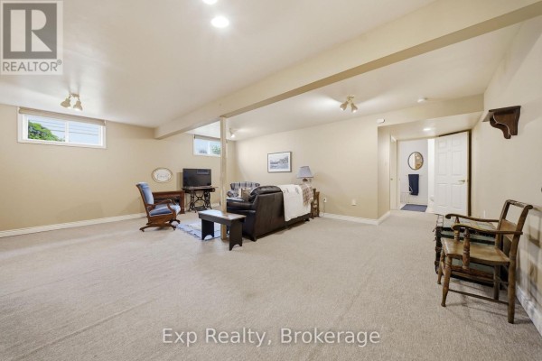 Living room with sofa, armchair, TV, and access to bathroom - 121 Simcoe Street Greater Napanee