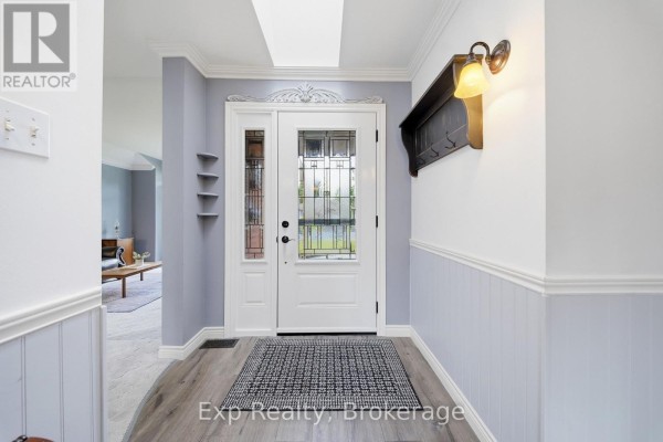 Glass panel front door with decorative shelving and coat rack in hallway - 121 Simcoe Street Greater Napanee