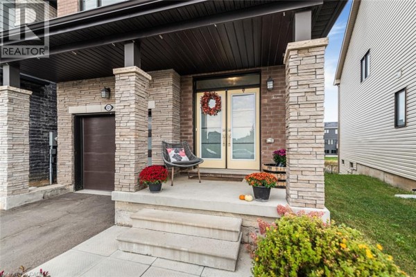 Close-up of the covered front porch of 121 Vanilla Trail, with brick pillars and double doors. - 121 Vanilla Trail, Thorold