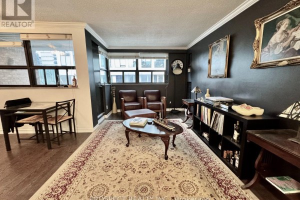 Living room with dark walls, leather chairs, coffee table, and built-in shelving. - 1210 - 120 Saint Patrick Street N, Toronto