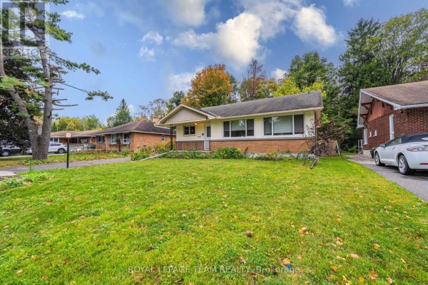 Side view of the house showcasing the attached garage and manicured lawn. - 1210 Adirondack Drive, Ottawa