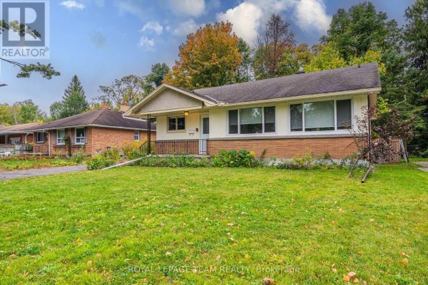 A wider shot of the property from the left, showing the garage and house exterior. - 1210 Adirondack Drive, Ottawa
