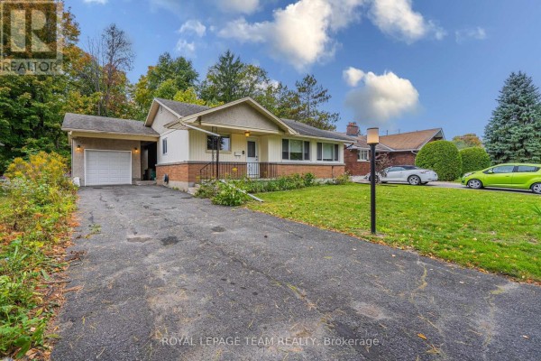 View of the driveway leading to the single-car garage of the bungalow. - 1210 Adirondack Drive, Ottawa