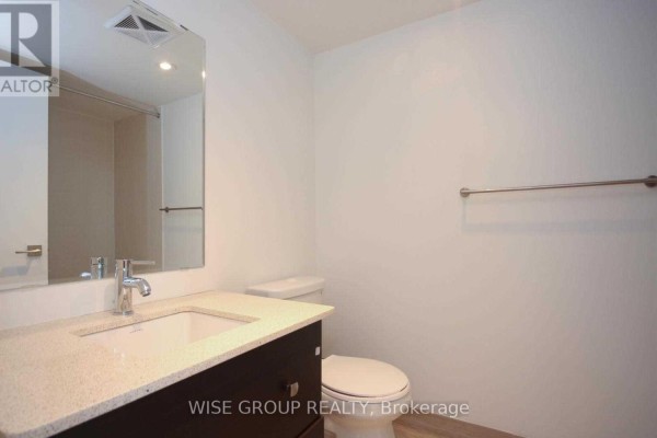 Bathroom with a white vanity, granite countertop, stainless steel faucet, and toilet. - 1210w - 565 Wilson Avenue, Toronto