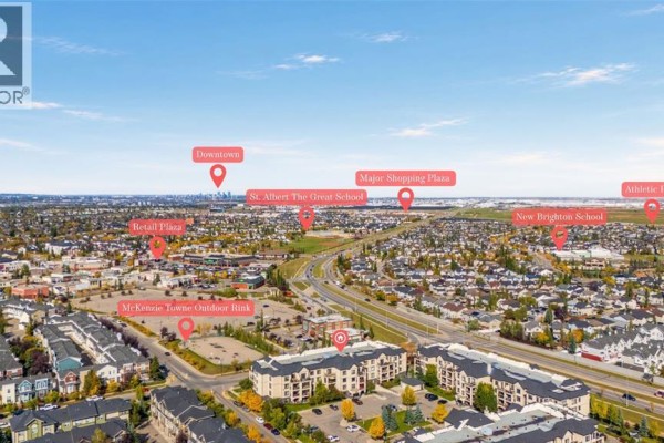 Aerial view of a suburban area with apartment buildings, marked points of interest, and distant city skyline. - 1211, 310 Mckenzie Towne Gate Se, Calgary