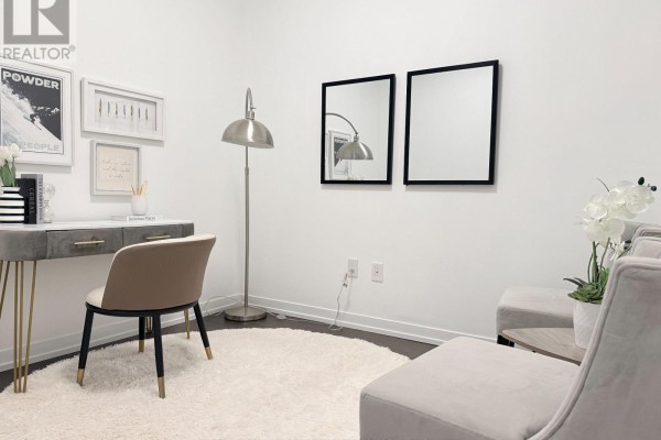 Study area featuring a desk, chair, floor lamp, two mirrors, and two chairs with a small table. - 1211 - 2520 Eglinton Avenue W, Mississauga