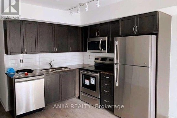 A modern kitchen with dark wood cabinets, stainless steel appliances, and white subway tile backsplash. - 1211 - 3091 Dufferin Street, Toronto