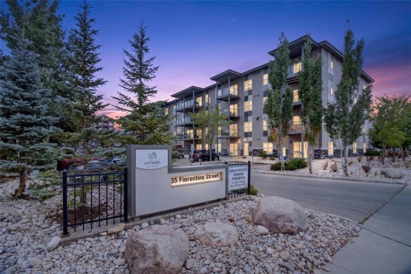 Exterior view of a modern apartment building with balconies and trees at dusk. - 1213 65 Fiorentino Street, Winnipeg