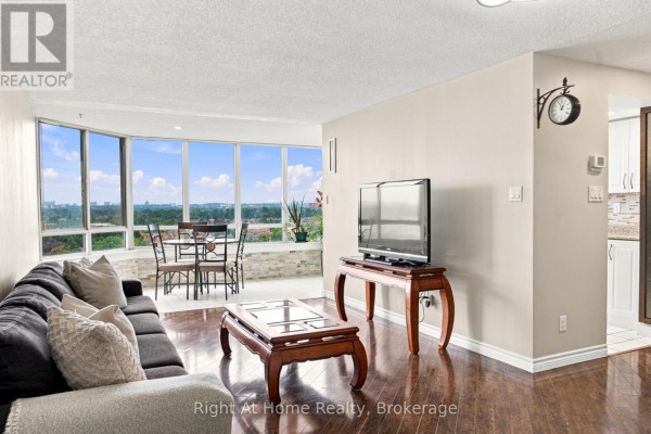 Kitchen with white cabinets, granite countertops, double sink, and tiled flooring. - 1215 - 11753 Sheppard Avenue E, Toronto