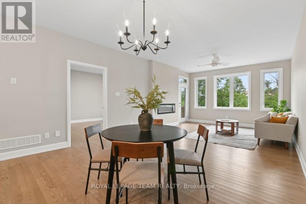 Dining table and living room area with sofa and fireplace - 1217 Potter Drive Brockville