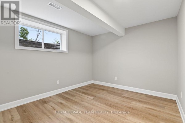 Basement with vinyl plank flooring and large window - 1217 Potter Drive Brockville