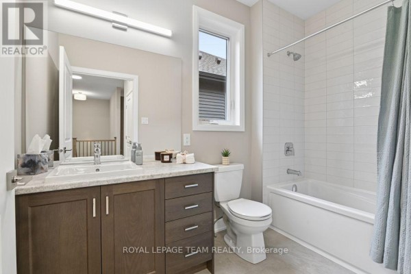Modern bathroom with dual tone vanity, large mirror, and tub/shower combo - 1217 Potter Drive Brockville