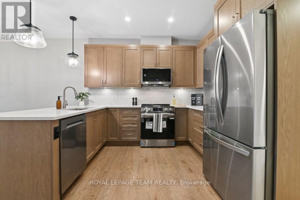 Modern kitchen with stainless steel appliances, quartz countertops, and light wood cabinets - 1217 Potter Drive Brockville