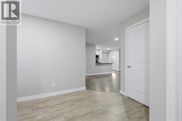Small bathroom with a white toilet, vanity, granite countertop, and mirror. - 1219, 625 Glenbow Drive, Cochrane