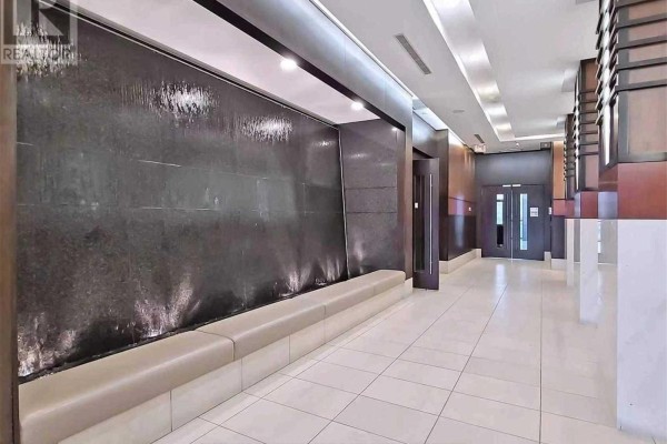 Interior hallway with a water feature wall, beige bench seating, and tiled floors. - 1219 - 33 Cox Boulevard, Markham