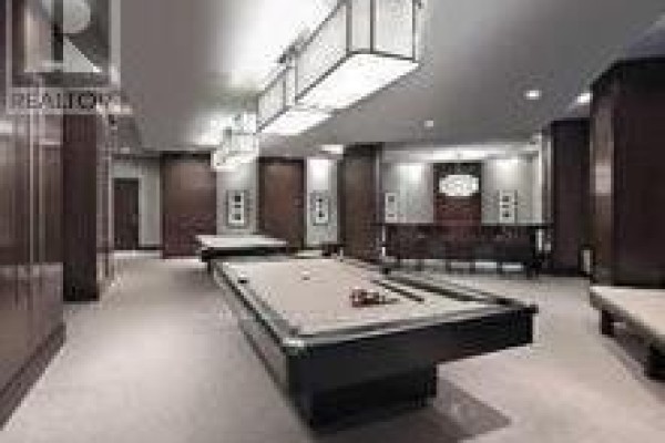 Room with two pool tables, overhead lighting, wood paneling, and seating areas. - 1219 - 33 Cox Boulevard, Markham