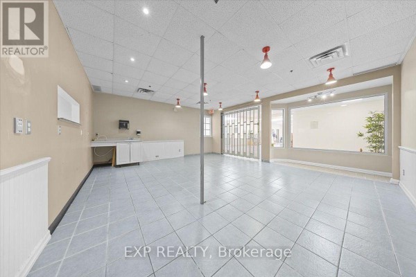 Empty commercial space with tiled floors, a sink and counter, and large windows. - 122 - 40 Sunset Boulevard, Perth