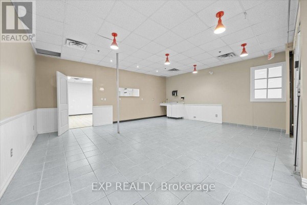 Empty commercial space with tiled floors, white wainscoting, a sink, and doors. - 122 - 40 Sunset Boulevard, Perth