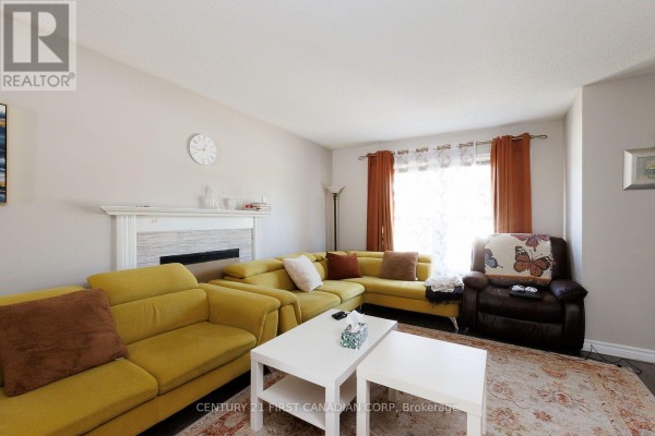 Living room with a fireplace, yellow sectional sofa, brown recliner, and a large window with orange curtains. - 122 - 70 Fiddlers Green Road, London North