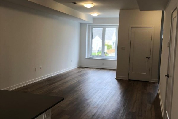Modern kitchen with white cabinetry, stainless steel refrigerator, stove, and microwave. - 122 - 781 Clare Avenue, Welland