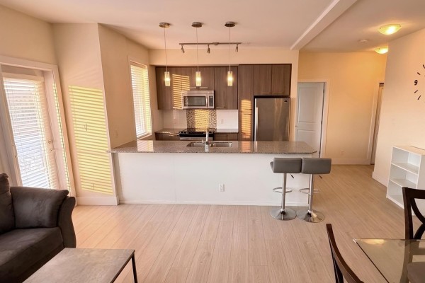 Kitchen with granite countertops, stainless steel appliances, and island with bar stools. - 122 15956 86a Avenue, Surrey