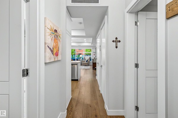 View down a hallway towards an open-concept kitchen, living area, and dining space. - #122 61 Festival Wy, Sherwood Park
