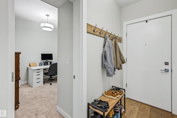 Hallway leading to a doorway showing a home office with a desk and computer. - #122 61 Festival Wy, Sherwood Park