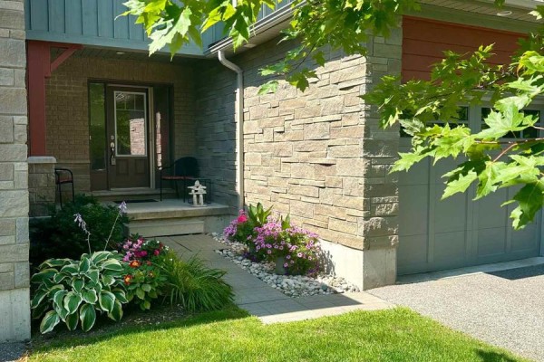 Exterior front view of townhouse complex garages and entrance. - 122 Conservation Way, Collingwood