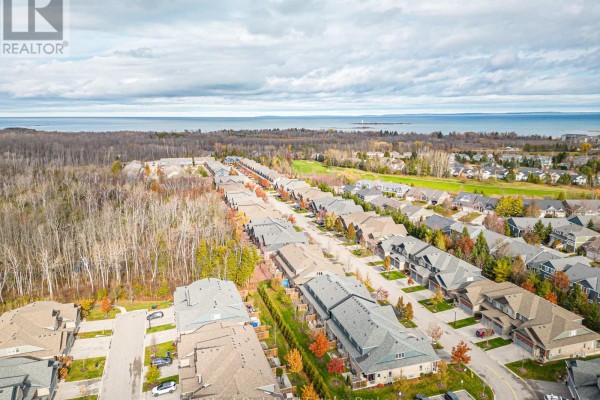 Aerial view of a residential street with townhouses and distant trees. - 122 Conservation Way, Collingwood