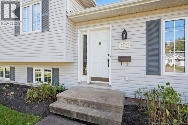 Close-up of the front entrance with a white door, grey shutters, and a mail slot. - 122 Dolbeau Street, Dieppe