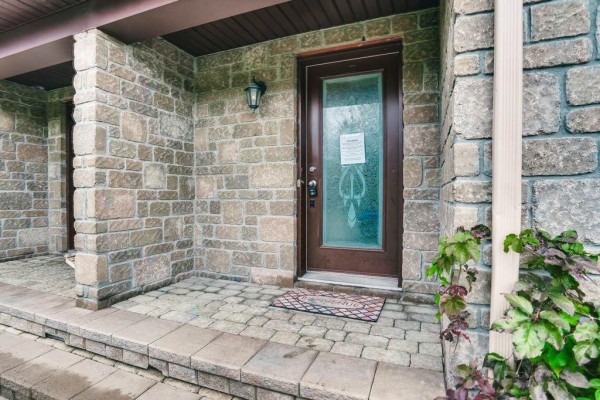 Close-up of the front door entrance with stone facade and covered porch. - 122 Rue Du Totem, Gatineau