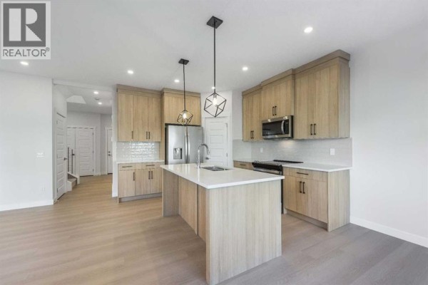Kitchen view highlighting dishwasher, sink, and modern cabinetry - 122 Sandpiper Bend, Chestermere