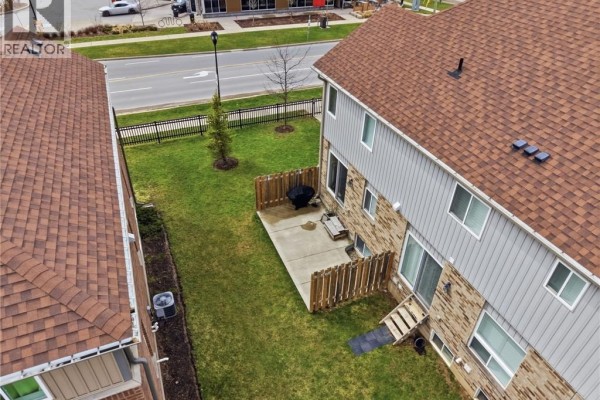 Living room with sectional sofa, television, and wooden floors. - 1220 Riverbend Road Unit# 105, London