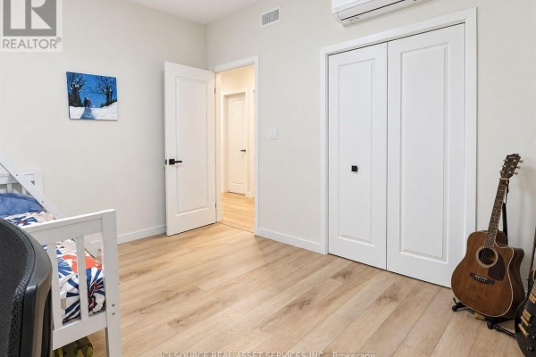 Bedroom with bunk beds, closet doors, and a guitar leaning against the wall. - 1221 Meadowlands Drive E, Ottawa