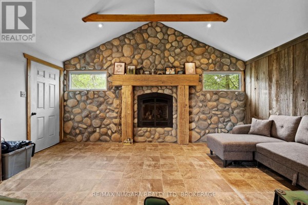 Interior of a rustic room under renovation with exposed wooden walls, floor, and ceiling beams. - 12213 Lakeshore Road, Wainfleet