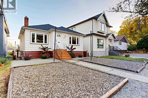 Side view of a white, two-story house attached to the front house, with stone and siding. - 1222 E 51st Avenue, Vancouver