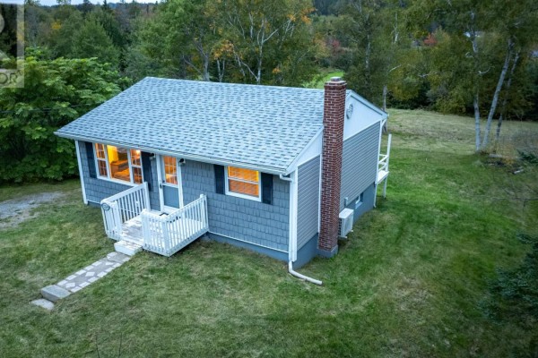 Side view of a grey vinyl-sided bungalow with white trim and a red brick chimney. - 1224 Georges River Rd Road, Georges River