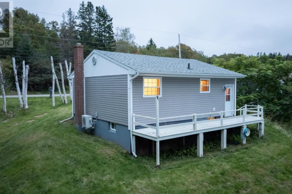 Rear view of a grey vinyl-sided bungalow with a large wooden deck and white railing. - 1224 Georges River Rd Road, Georges River