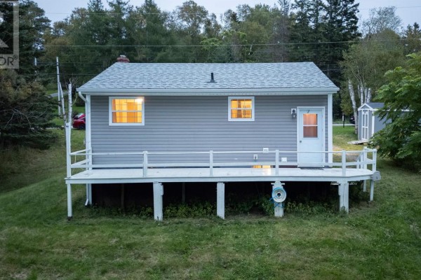 Back view of a grey vinyl-sided bungalow with a white door and a white wooden deck. - 1224 Georges River Rd Road, Georges River