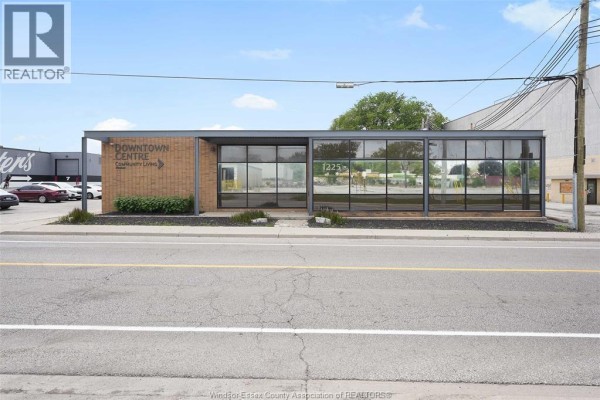 Side exterior of a commercial building with brick and glass sections, facing a street. - 1225 Mcdougall, Windsor