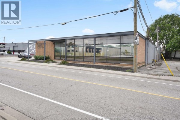 Corner view of a commercial building showing brick and glass facade, entrance, and street access. - 1225 Mcdougall, Windsor