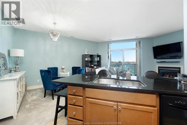 Kitchen island with granite countertops, fireplace, and large window view - 1225 Riverside Unit# 409 Windsor