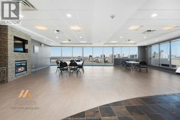 Living room with fireplace, TV, and city view - 1225 Riverside Unit# 409 Windsor